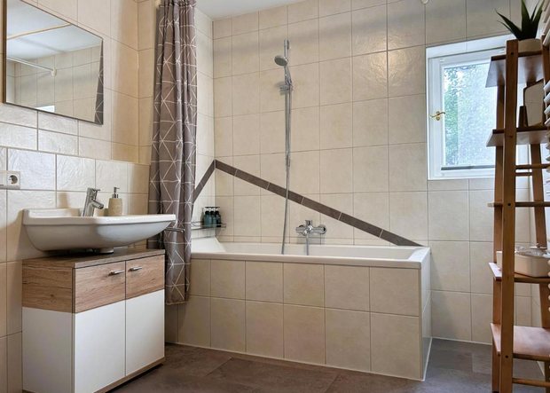 Badezimmer mit Badewanne und Dusche